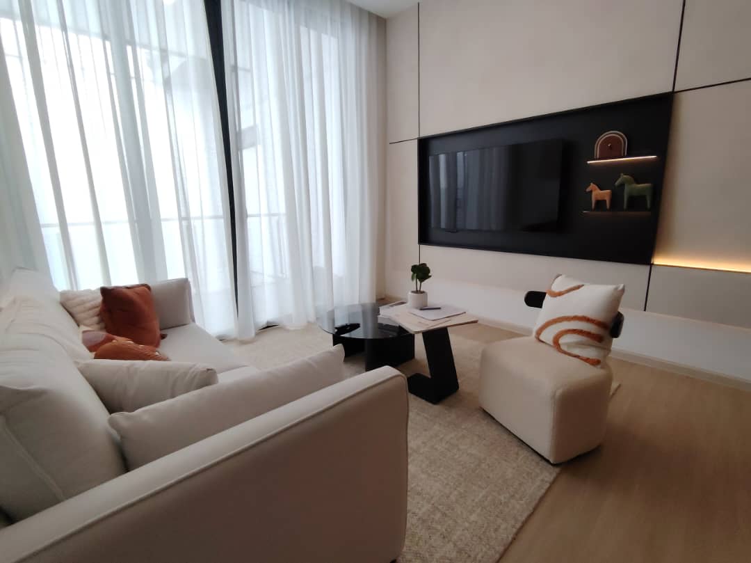 Bright living room with built-in TV feature wall and sheer curtains